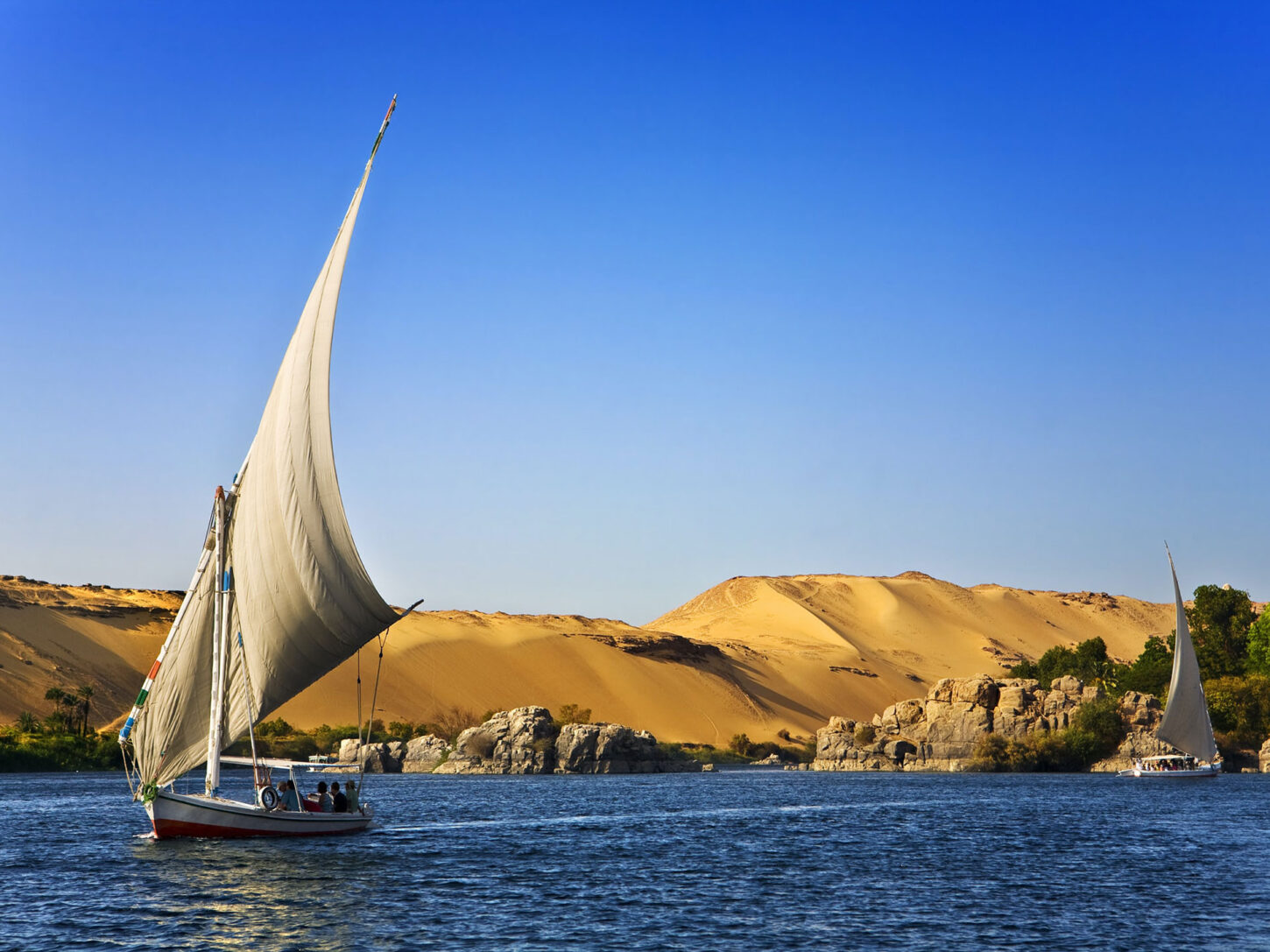 Ein Segelschiff vor einem Ufer mit Sanddünen, Symbolbild für die Raw Yarn Kollektion Giza Premium, Luxus-Baumwolle aus Ägypten.